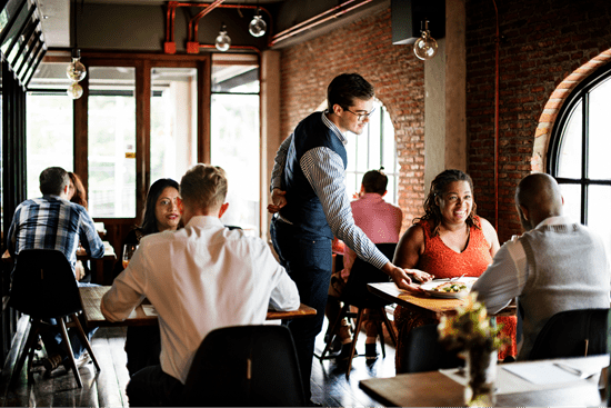 a photo of a server in foh (front of house) bringing a table their food