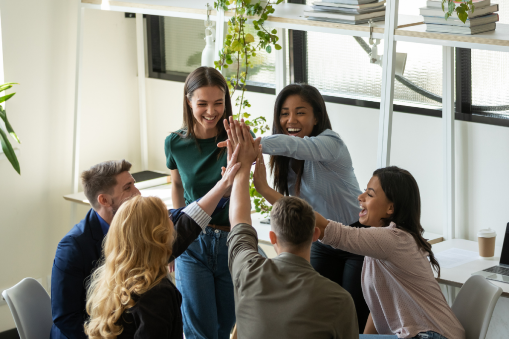 a diverse, high-performing team giving high fives to each other