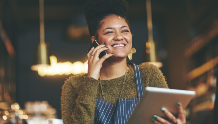 A restaurant or bar operator on the phone with a tablet in hand.
