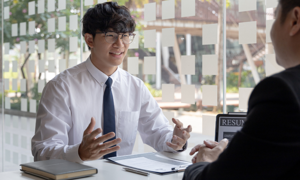 How To Build A Winning Internship Program 2 Smiling intern in glasses during an interview for an internship program.