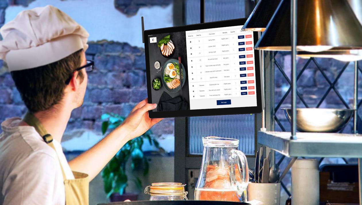 Restaurant manager reviewing sales data on a screen to build the weekly schedule