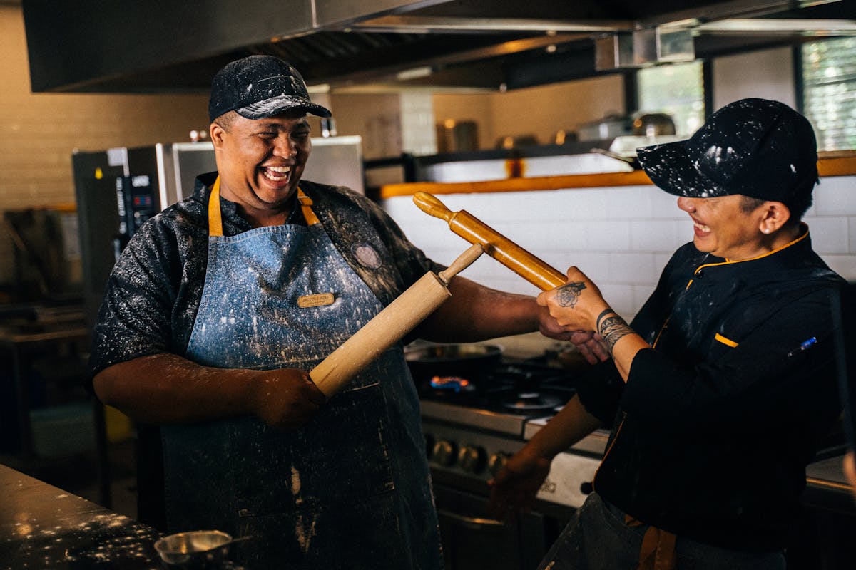 Restaurant kitchen workers smiling together during service