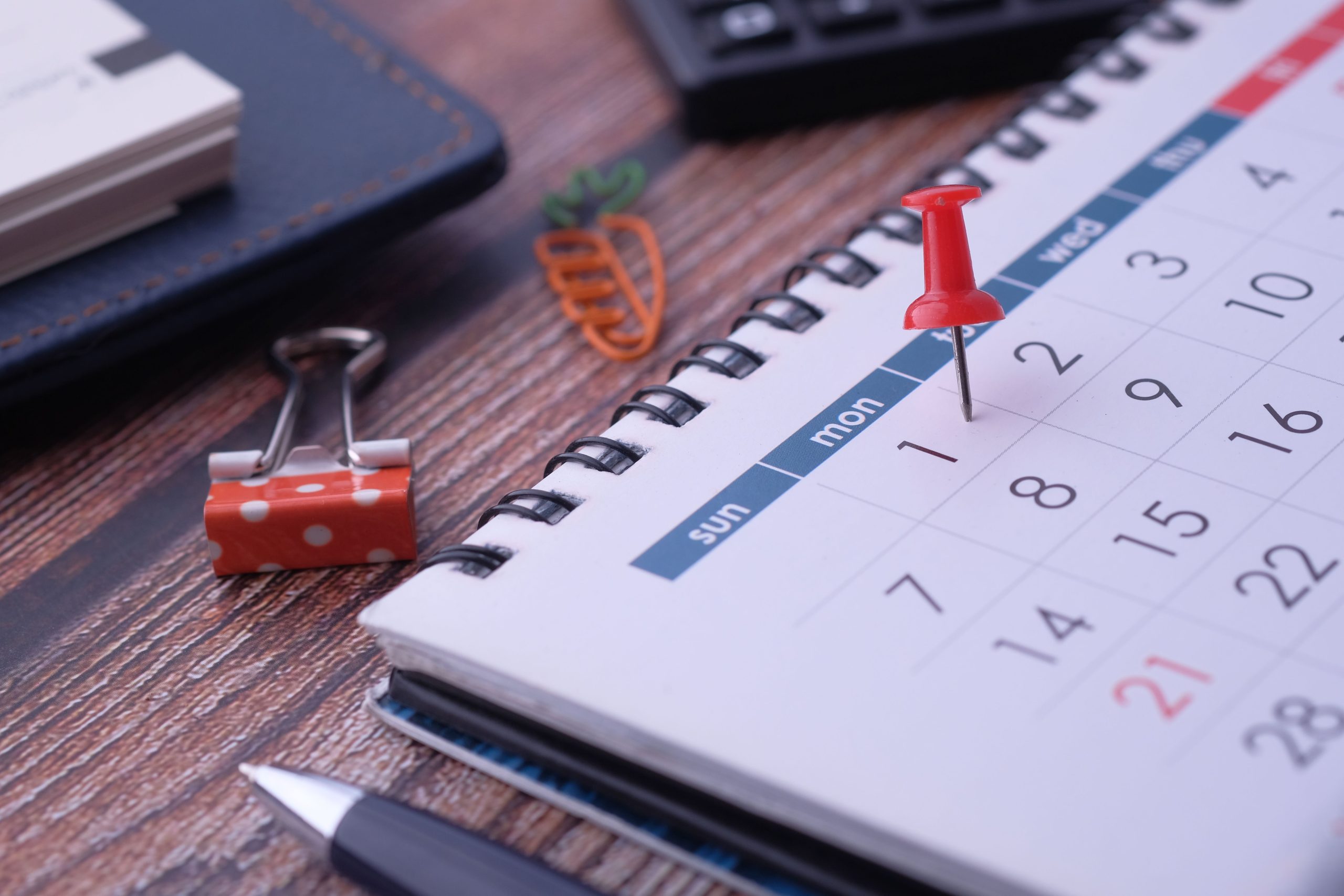 Calendar with planning pins on a desk representing restaurant scheduling and blackout dates